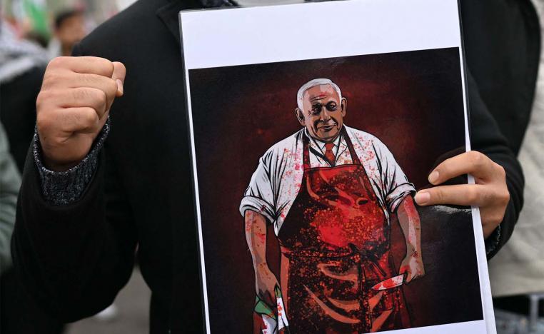 A demonstrator holds a placard depicting Israeli PM  during a Pro-Palestinian rally in Warsaw