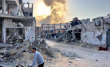 فلسطيني بالقرب من اطلال لأبنية مدمرة بالقصف في غزة