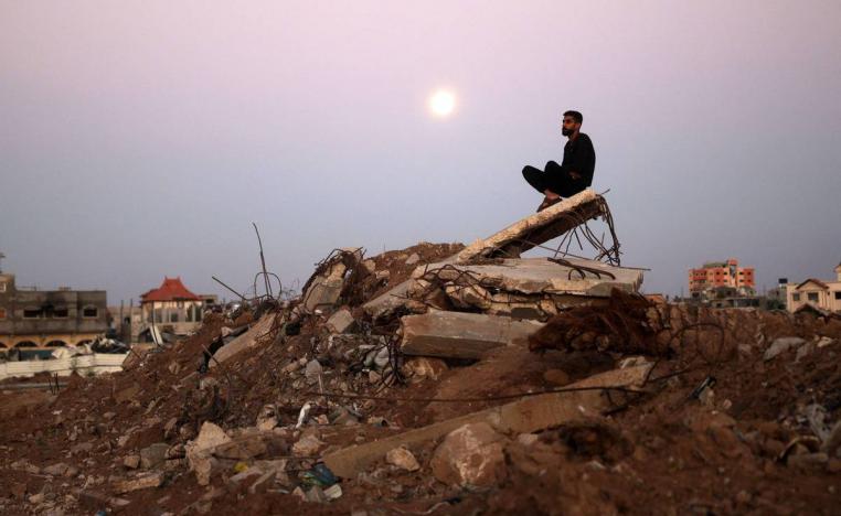 فلسطيني يجلس على انقاض مبنى مدمر في البريج في غزة
