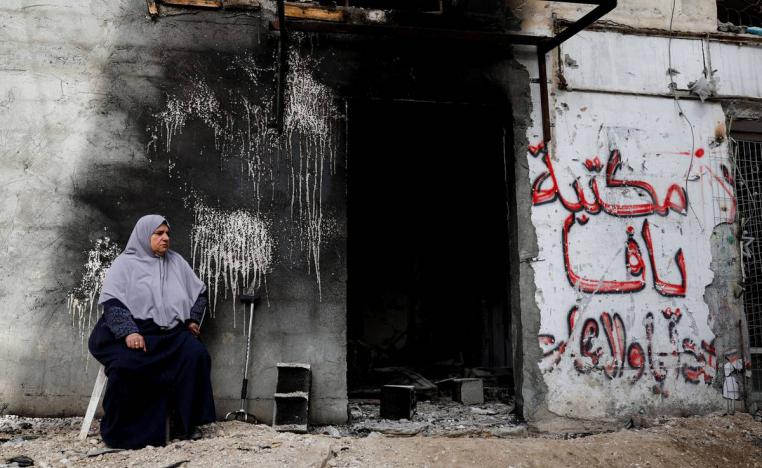 فلسطينية في طولكرم بجانب محل مدمر