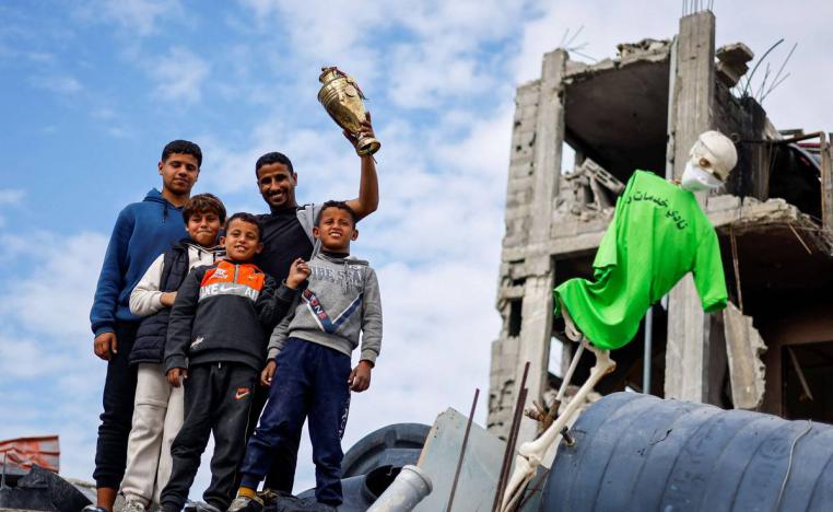لاعب المنتخب الفلسطيني أحمد اللولحي يستخلص كأس بطولة سابقة من منزله المدمر