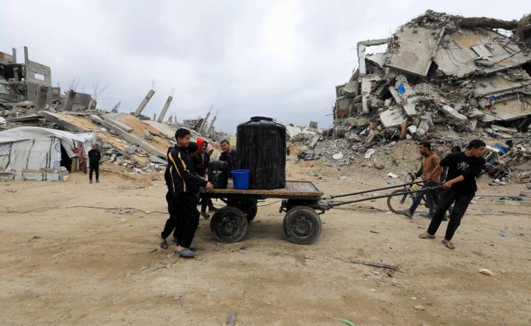 أطفال فلسطينيون ينقلون وقودا في شوارع غزة المهدمة