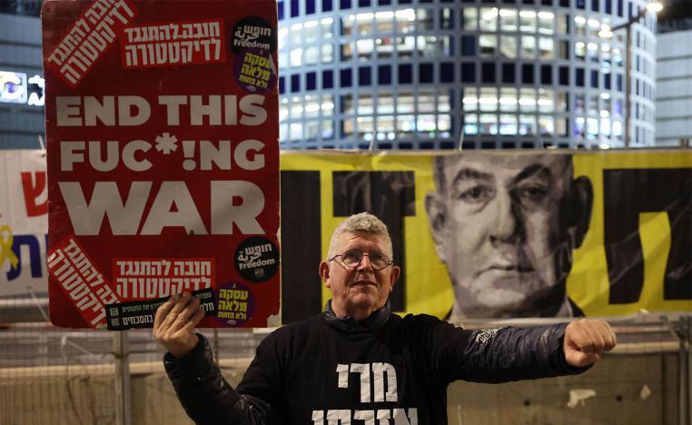 A demonstrator raises a placard during a protest calling for the release of hostages in front of the Israeli Defence Ministry in Tel Aviv 