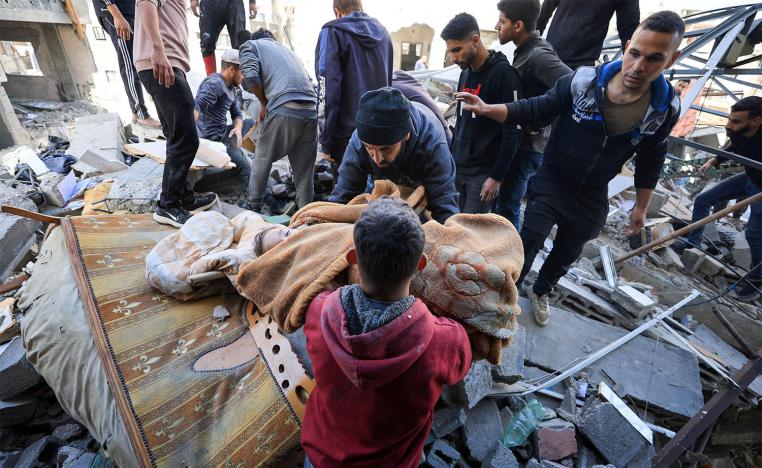 A man carries the body of a Palestinian child killed in an Israeli airstrike on Gaza