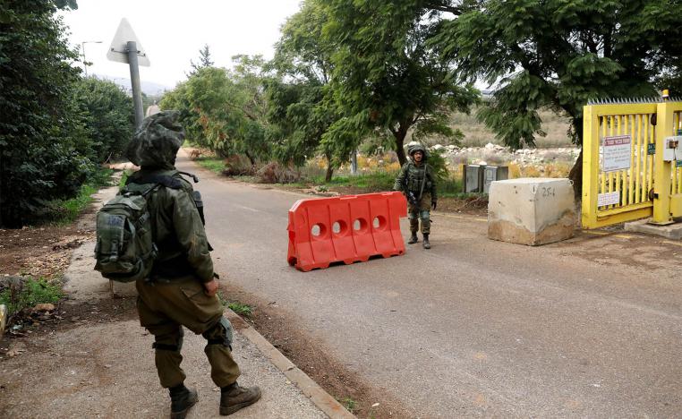 Israeli soldiers guard near an barrier blocking an entrance leading to the border with Lebanon