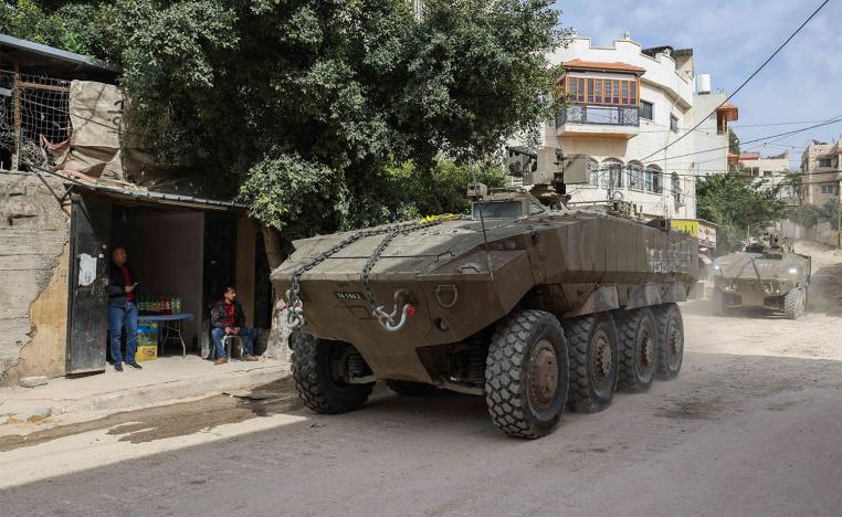 Israeli armoured vehicles drive by during a raid in the eastern neighbourhood of Jenin in the occupied West Bank