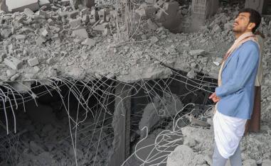 يمني ينظر إلى ثغرات احدثتها قنابل أميركية في قصف لأبنية في صنعاء