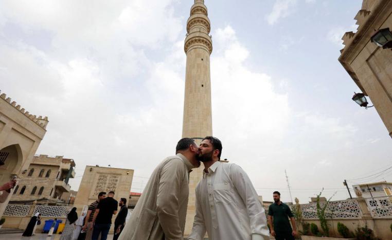 عراقيان يتعانقان في الموصل بمناسبة عيد الفطر