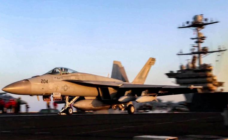 A US F/A-18 fighter aircraft taking off from an aircraft carrier at sea reportedly amidst operations launched against Houthis in Yemen