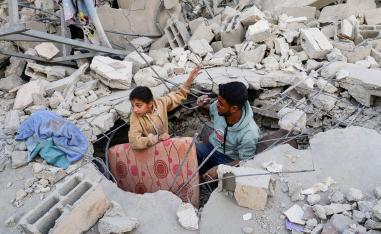 Palestinians inspect the site of an Israeli strike on a house, in Khan Younis 
