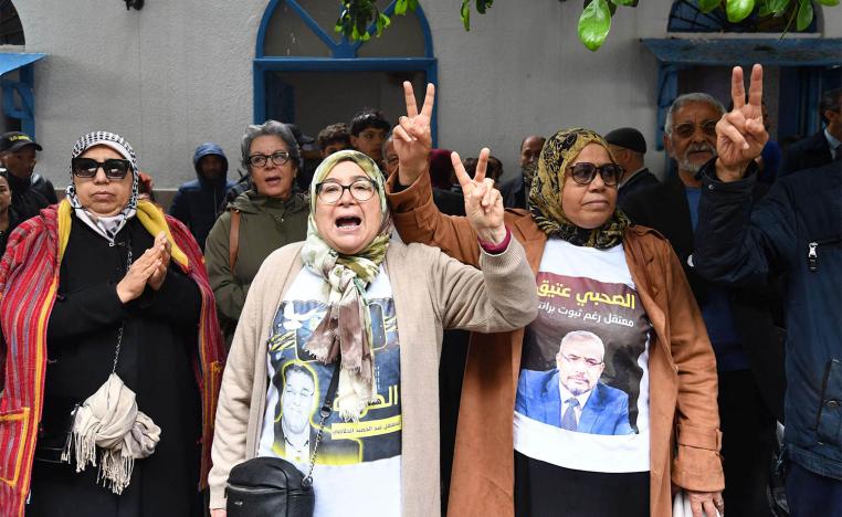 Families and relatives of the detained political opposition figures in the so-called conspiracy against state security case hold up photos of the detainees during a demonstration in front of the court in Tunis