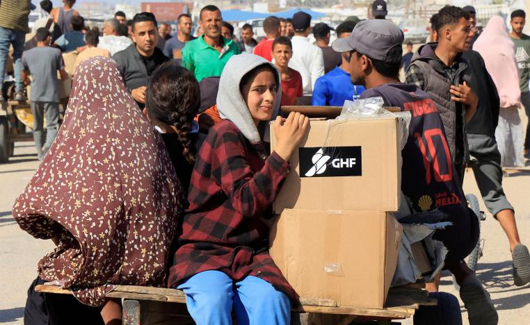 People ride a cart as Palestinians seeking aid gather near an aid distribution site run by the US-backed Gaza Humanitarian Foundation in Rafah