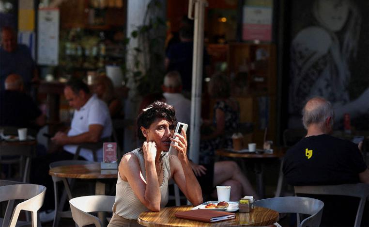 Israelis sit at a cafe, after US President Trump announced a ceasefire between Israel and Iran, in Haifa
