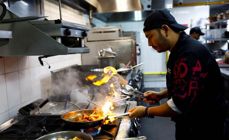 Chef Khimraj Nepali prepares a dish using the recipe from Aiman, the AI Chef