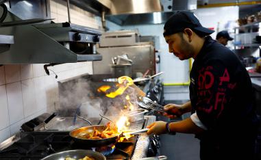 Chef Khimraj Nepali prepares a dish using the recipe from Aiman, the AI Chef