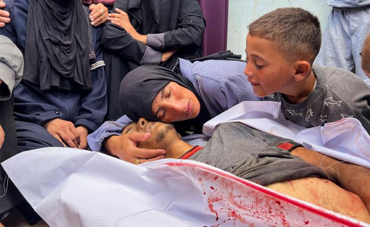 The mother of Hesham Ifsifis, who was killed in Israeli fire while seeking aid near a distribution point mourns over his body