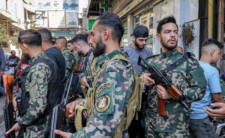 عشرات المقاتلين بزي عسكري يحملون بنادق من طراز كلاشينكوف يظهرون في برج البراجنة