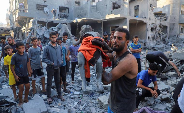 A man carries the body of Palestinian girl Amal Zakot, who was killed in an Israeli strike on a house in Gaza City