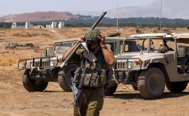 An Israeli army soldier adjusts his helmet 