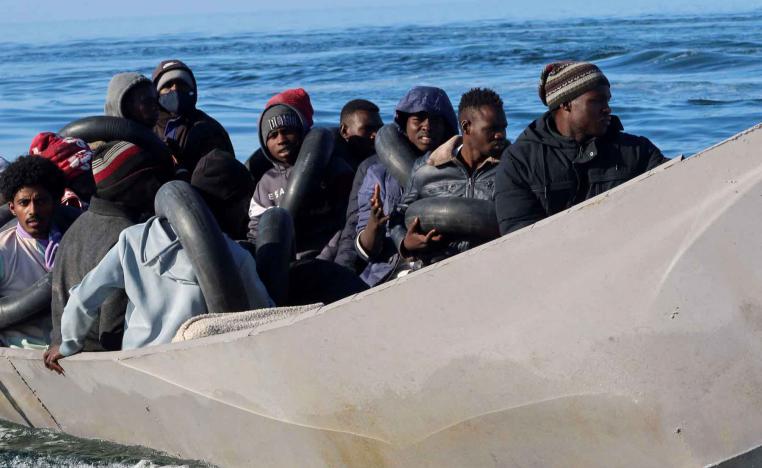 Migrants are pictured on a metal boat as Tunisian coast guards try to stop them at sea during their attempt to cross to Italy, off Sfax, Tunisia. 