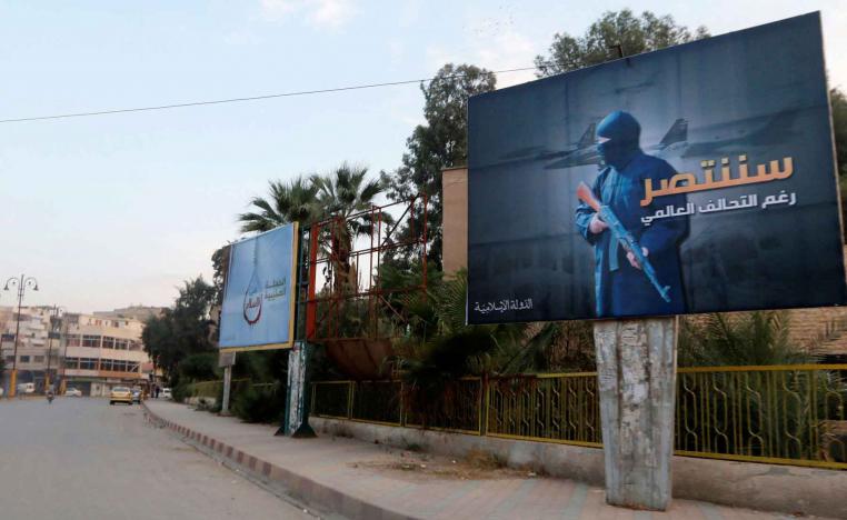 A 2014 file picture shows Islamic State billboards are seen along a street in Raqqa, eastern Syria. The billboard (R) reads: “We will win despite the global coalition.” 