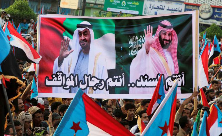 People hold a banner with images of the Emirati President Sheikh Mohamed bin Zayed Al Nahyan and Saudi Crown Prince Mohammed bin Salman during a rally organised by Yemen’s Southern Transitional Council in Aden, December 21, 2025. 