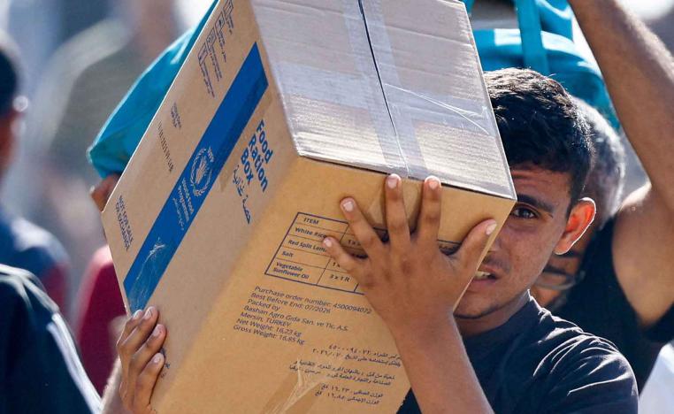  A Palestinian carries aid supplies that entered Gaza in Zawaida in the central Gaza Strip, October 21, 2025. 