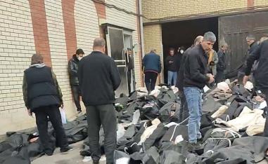 Bodies lie in body bags on the ground as people stand amid the scene outside Kahrizak Forensic Medical Centre in Tehran