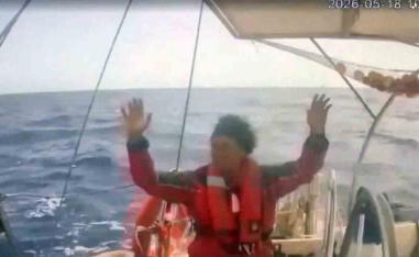 An activist raises his hand as an Israeli naval boat intercepts the Global Sumud Flotilla en route to Gaza, in an attempt to deliver aid, at sea