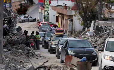Displaced people transport their belongings in cars, as they make their way back to their homes in southern Lebanon