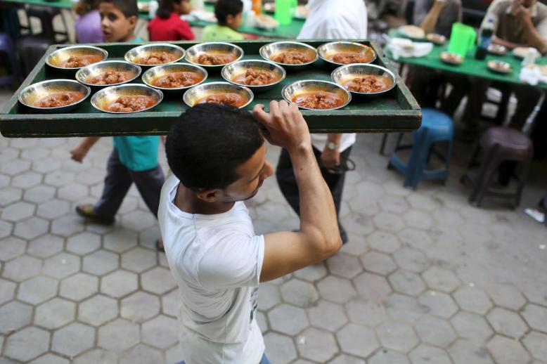 A volunteer carries food to charity tables in Cairo