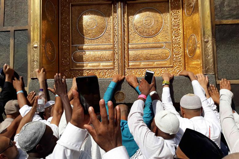 حجاج يصورون بهواتفهم الذكية جانبا من الطواف حول الكعبة