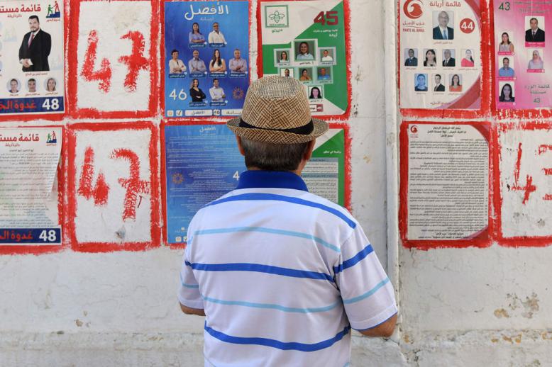 A Tunisian man looks at posters of legislatives' candidates in the capital Tunis