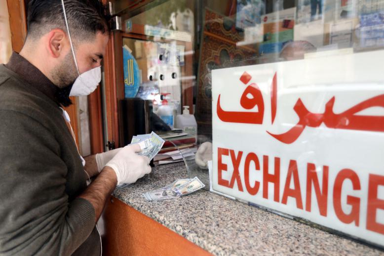 A customer is served at the counter of a currency exchange store in Beirut