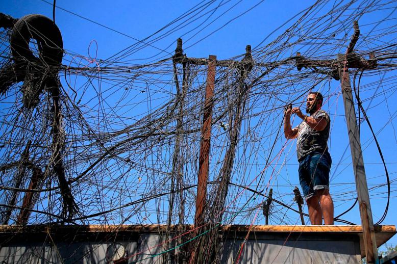 عراقي وسط شبكة توزيع كهرباء خاصة في بغداد