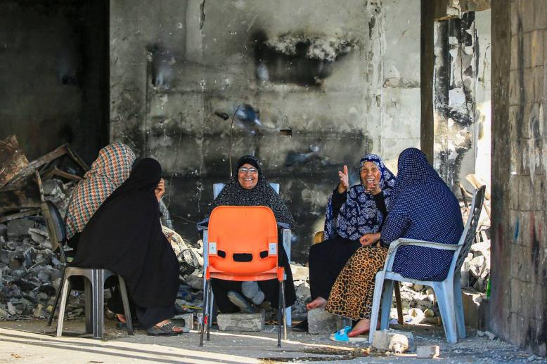 فلسطينيات في مبنى مدمر من القصف في غزة