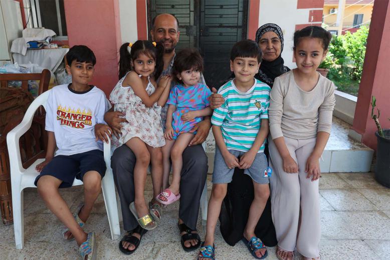 Samer Abu Della, displaced Lebanese from southern border village of Yarine, poses for a picture with his family