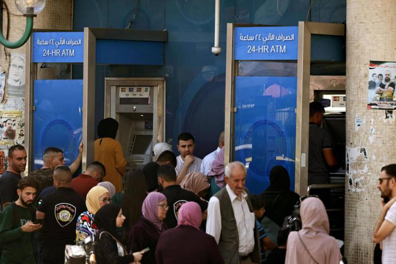 فلسطينيون يسحبون أموالا من مكائن الصرف في نابلس في الضفة الغربية