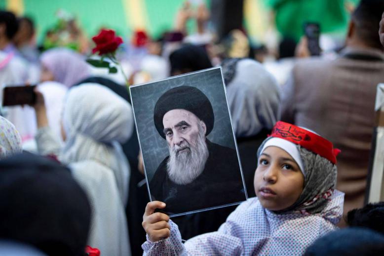 طفلة عراقية ترفع صورة آية الله علي السيستاني