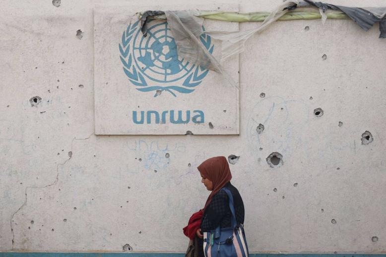 فلسطينية تمر بجانب مكتب الانروا في خان يونس