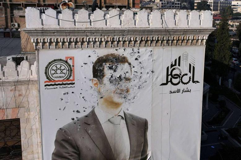 جدارية مشوهة للرئيس بشار الأسد وسط حماة