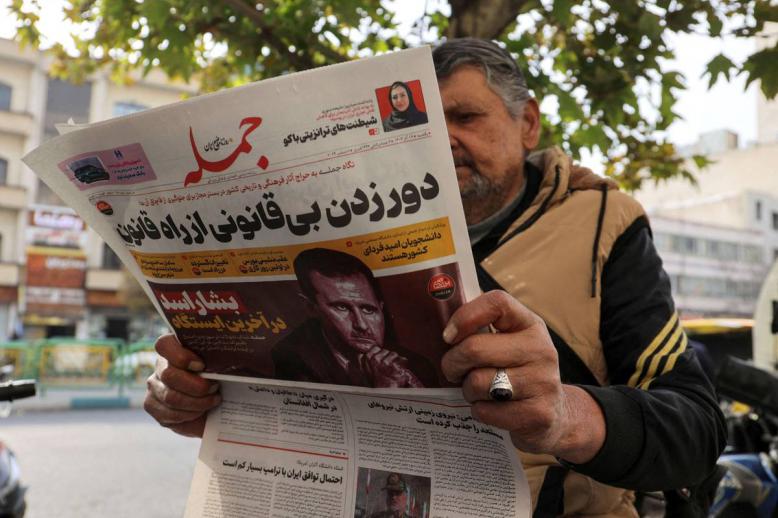 إيراني يتصفح جريدة في طهران