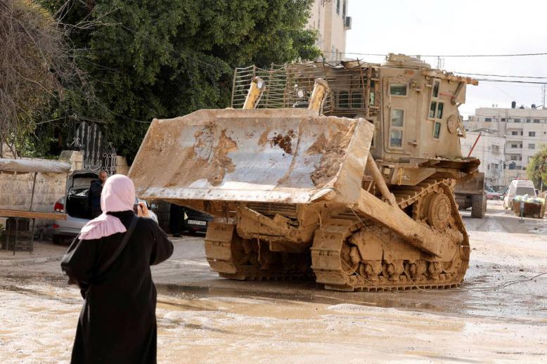 فلسطينية أمام جرافة إسرائيلية في مخيم جنين