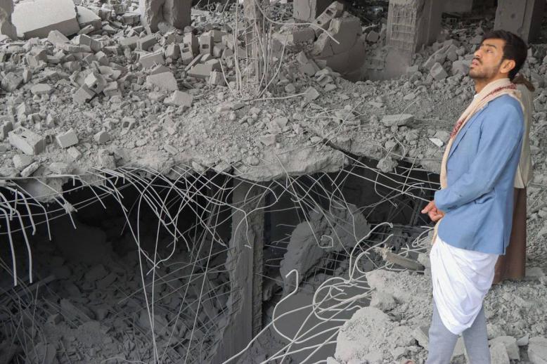 يمني ينظر إلى ثغرات احدثتها قنابل أميركية في قصف لأبنية في صنعاء