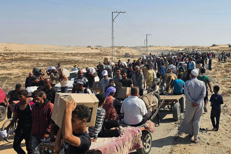Displaced Palestinians walk along a road to receive humanitarian aid packages from a US-backed foundation in Rafah in the southern Gaza Strip on June 