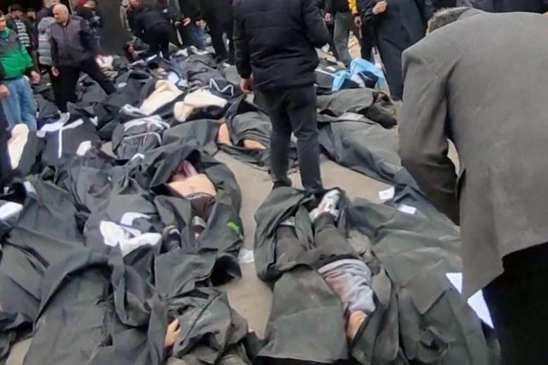 People gather next to bodies lying in body bags outside Kahrizak Forensic Medical Centre in Tehran