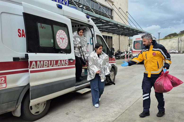 People rescued after a migrant boat sank off Turkey’s Aegean coast get out of an ambulance upon arrival at a hospital in Bodrum