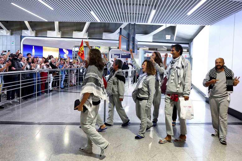 French activists from the Gaza-bound Global Sumud Flotilla gesture upon arrival at Charles de Gaulle Airport near Paris on May 22