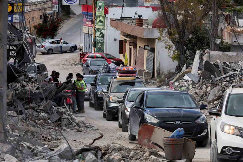 Displaced people transport their belongings in cars, as they make their way back to their homes in southern Lebanon