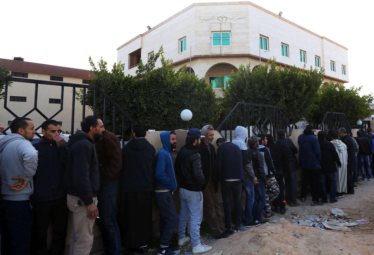 ليبيون يقفون أمام مصرف في طرابلس